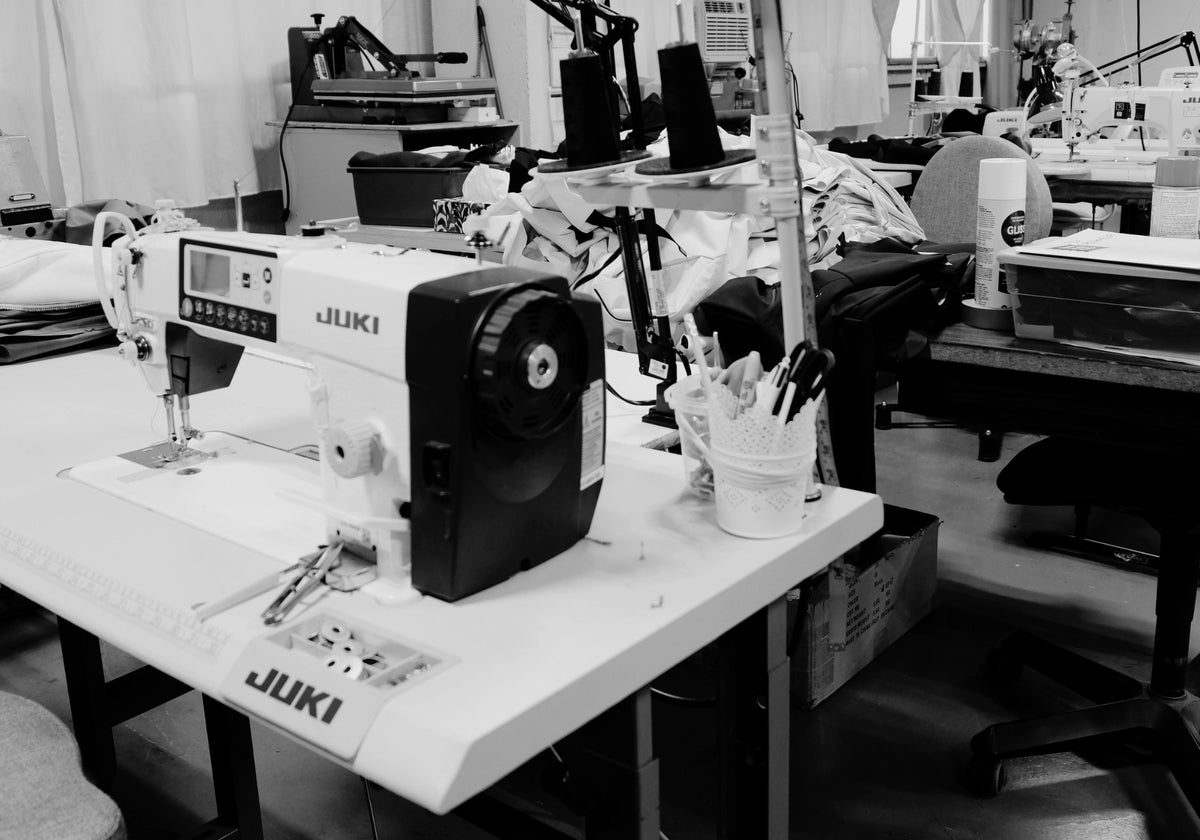 Photo en noir et blanc d'un poste de couture à l'atelier de fabrication Audvik situé à Montréal, Québec. 