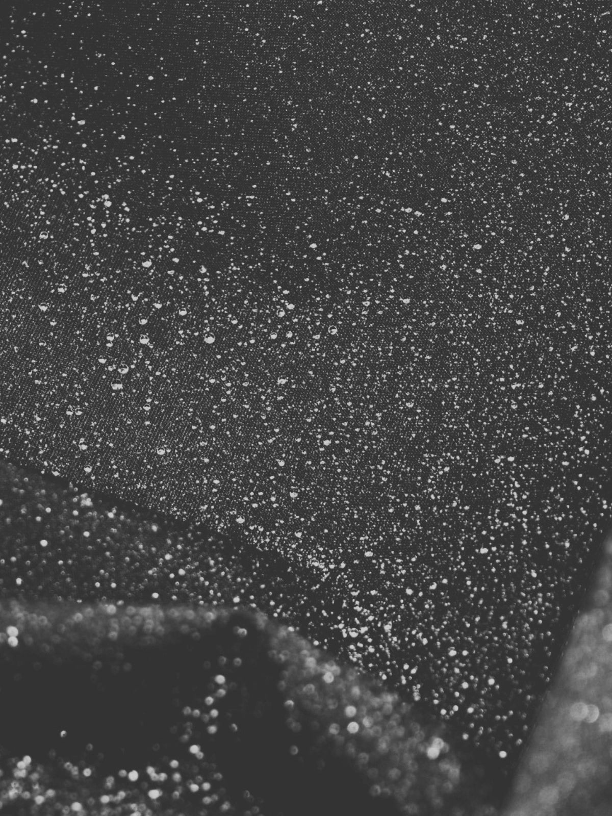 Photo en noir et blanc d'un tissu Audvik avec des gouttes d'eau.