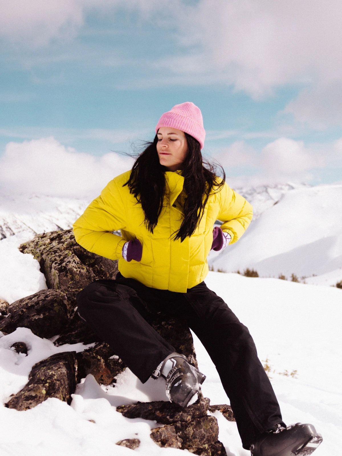 Femme assise sur un rocher dans un paysage hivernal portant une doudoune courte FOSFO