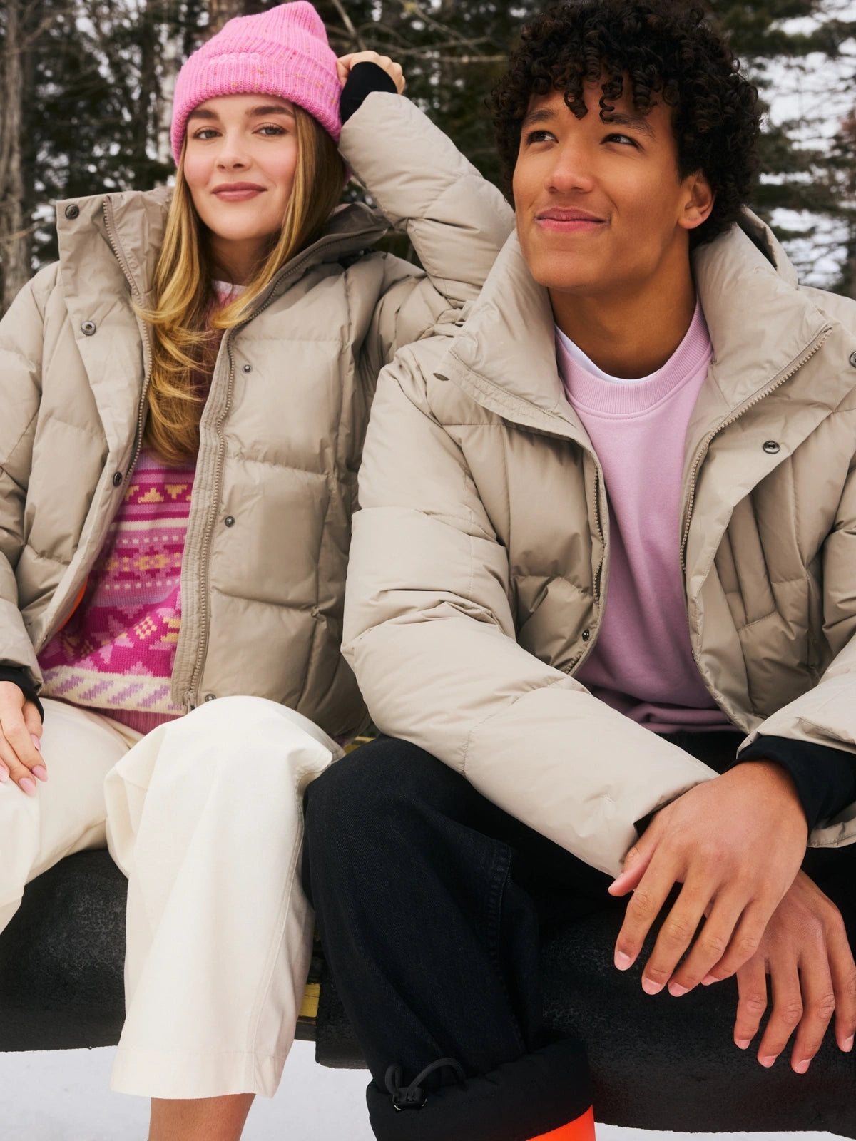 Un homme et une femme assis sur un banc portant chacun une doudoune courte beige durable FOSFO.