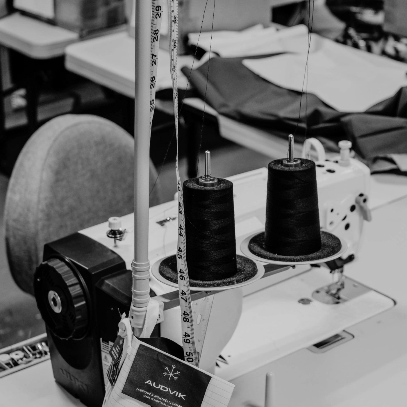 Photo en noir et blanc d'un poste de couture à l'atelier Audvik. 