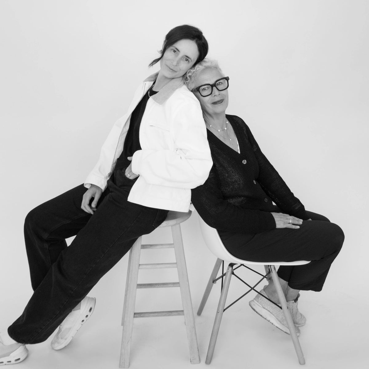 Sophie et Elise Boyer posant sur un fond blanc assises sur des chaises. 