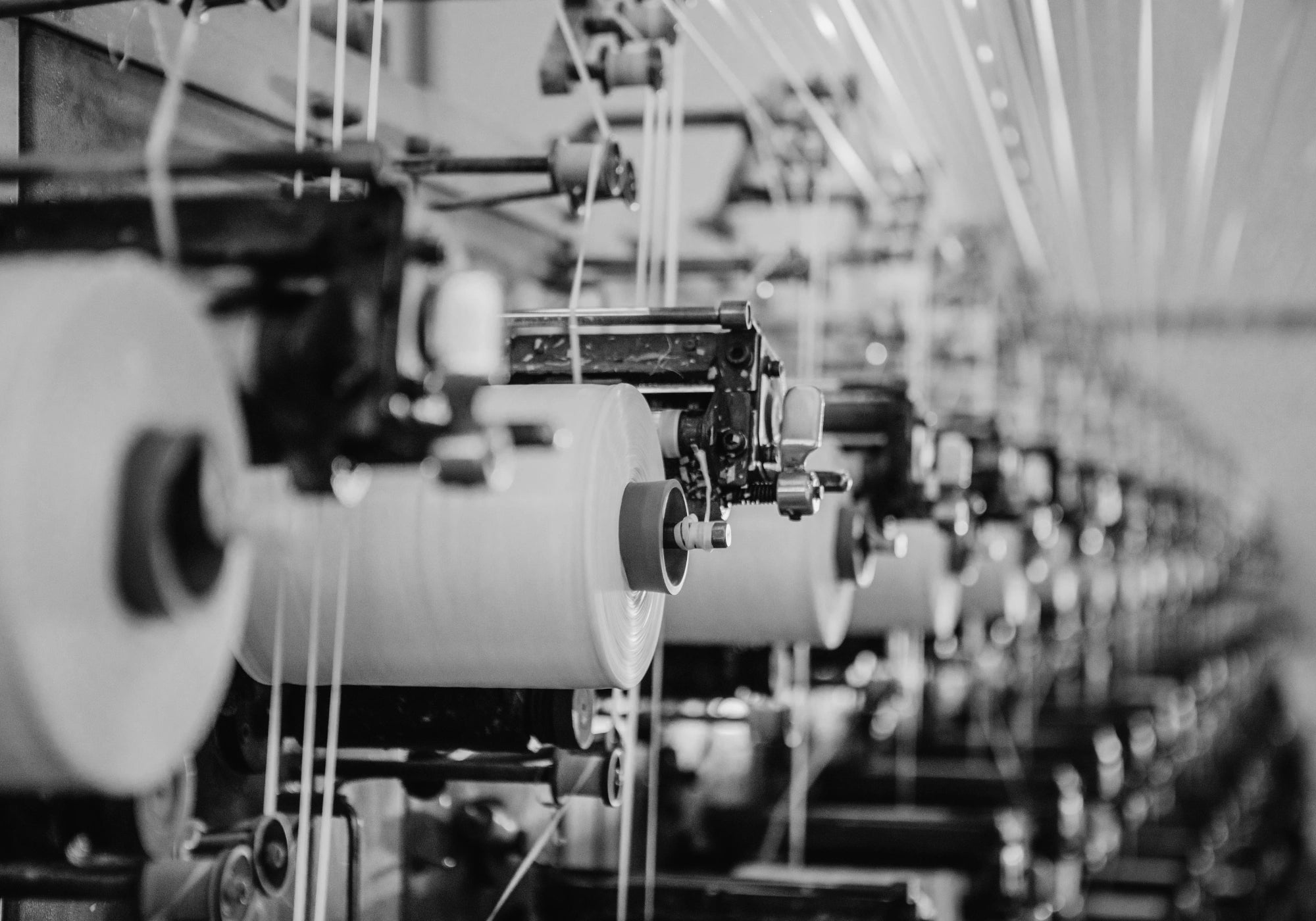 Photo en noir et blanc d'une machine industrielle de tissage.