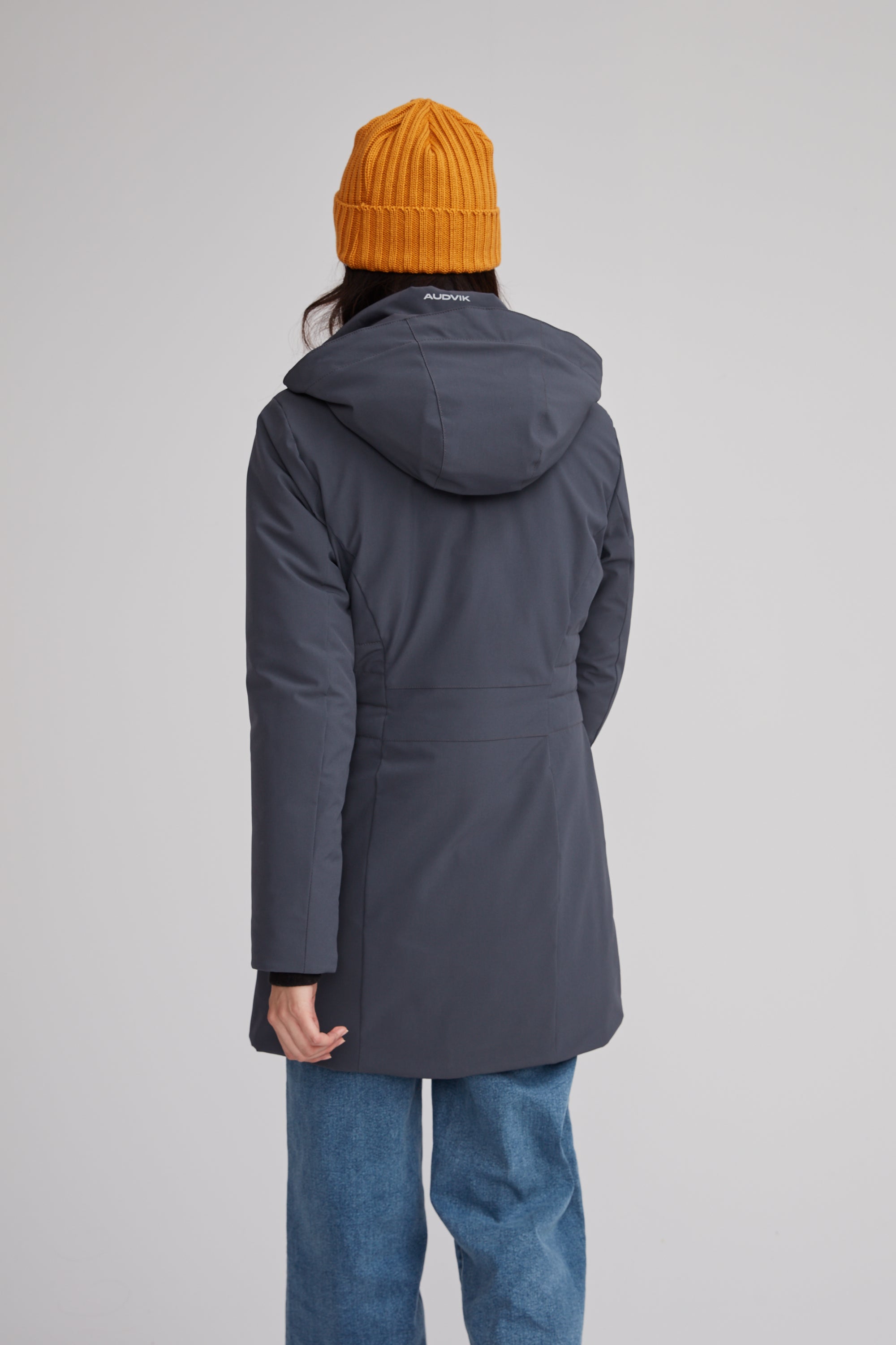 Manteau d'hiver mi-long pour femme. Manteau d'hiver fait au Québec, fait à partir de tissu performant. Manteau Imperméable, manteau coupe-vent et manteau respirant. Isolant synthétique et vegan. Manteau chaud gris.