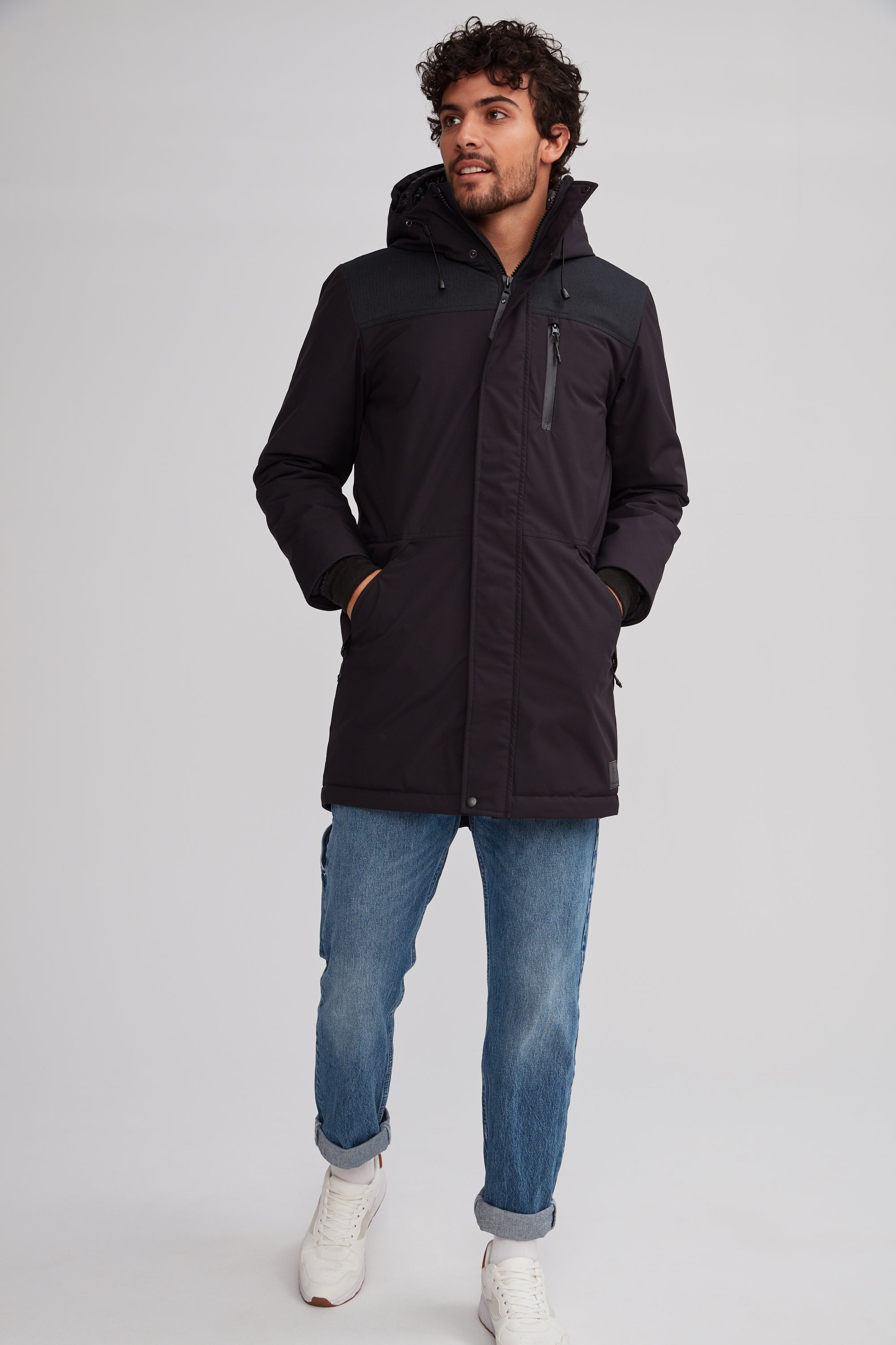 Manteau noir sportif pour homme. Double capuchon et coupe allongée au dos.